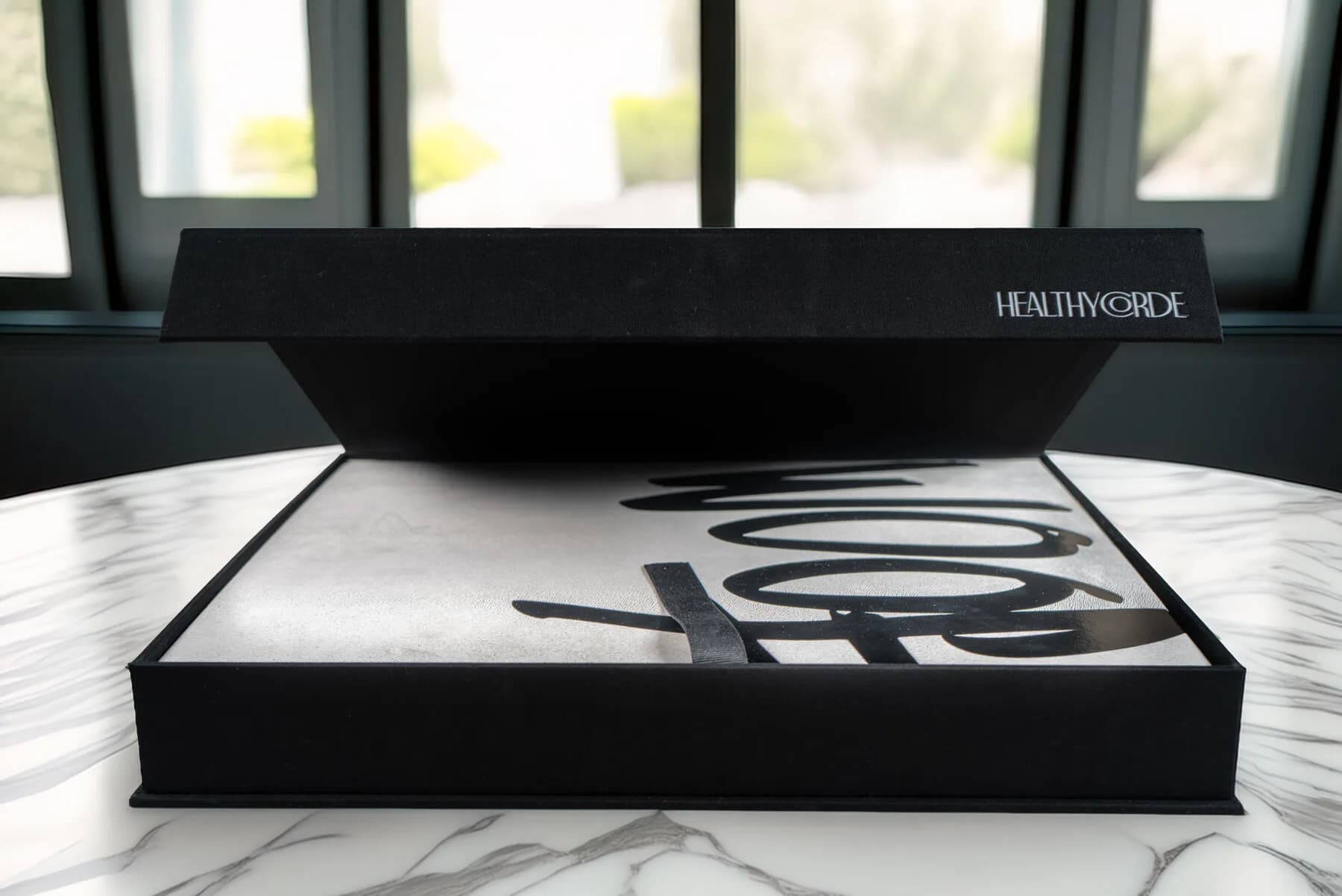 La caja de lino de WOOF sobre una mesa junto a una ventana, a contraluz